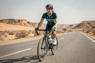 Kholoud Shahine Al-Kuwari, cycliste professionnelle qatarienne, pédalant sur une route désertique lors d'une session d'entraînement