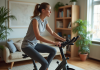 Femme en leggings faisant du vélo d'appartement chez elle