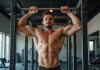 Jeune homme musclé faisant des tractions en salle de sport
