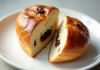 Pain aux raisins coupé en deux sur une assiette blanche